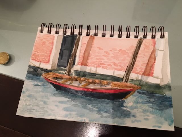 Plein aire watercolor painting of a small moored boat in a canal in Venice, Italy.